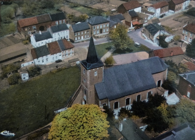 Vue aérienne d’un village avec une église entourée de maisons et d’arbres verts, dans une région où l’adoucisseur d’eau Minimax est actif.