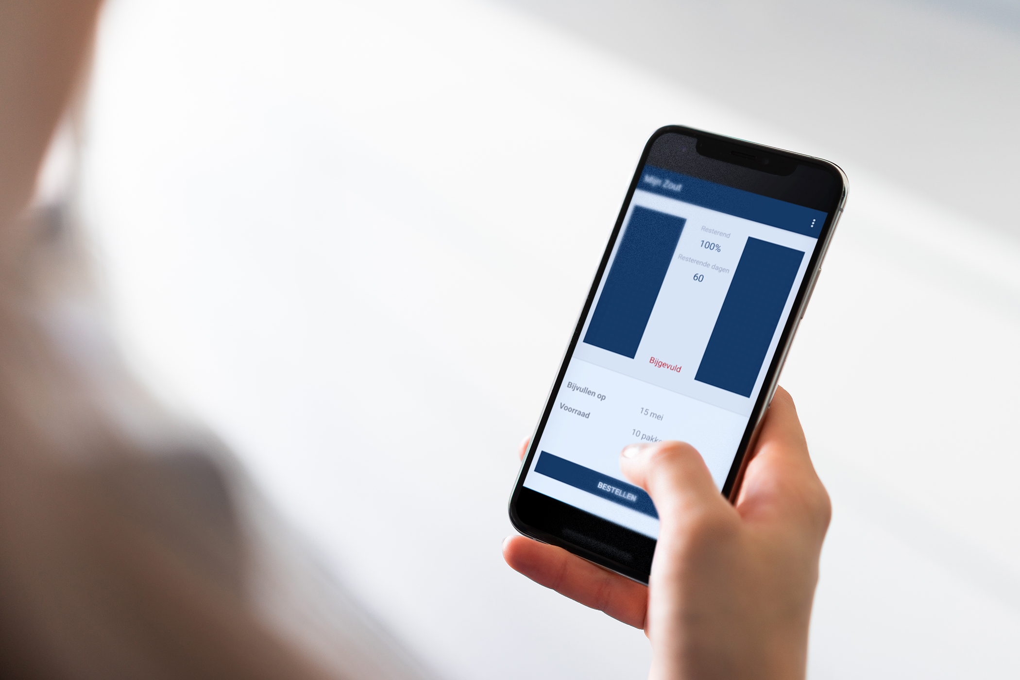 Personne tenant un smartphone avec une application affichant des informations de l’application de sel de l’adoucisseur d’eau Minimax.