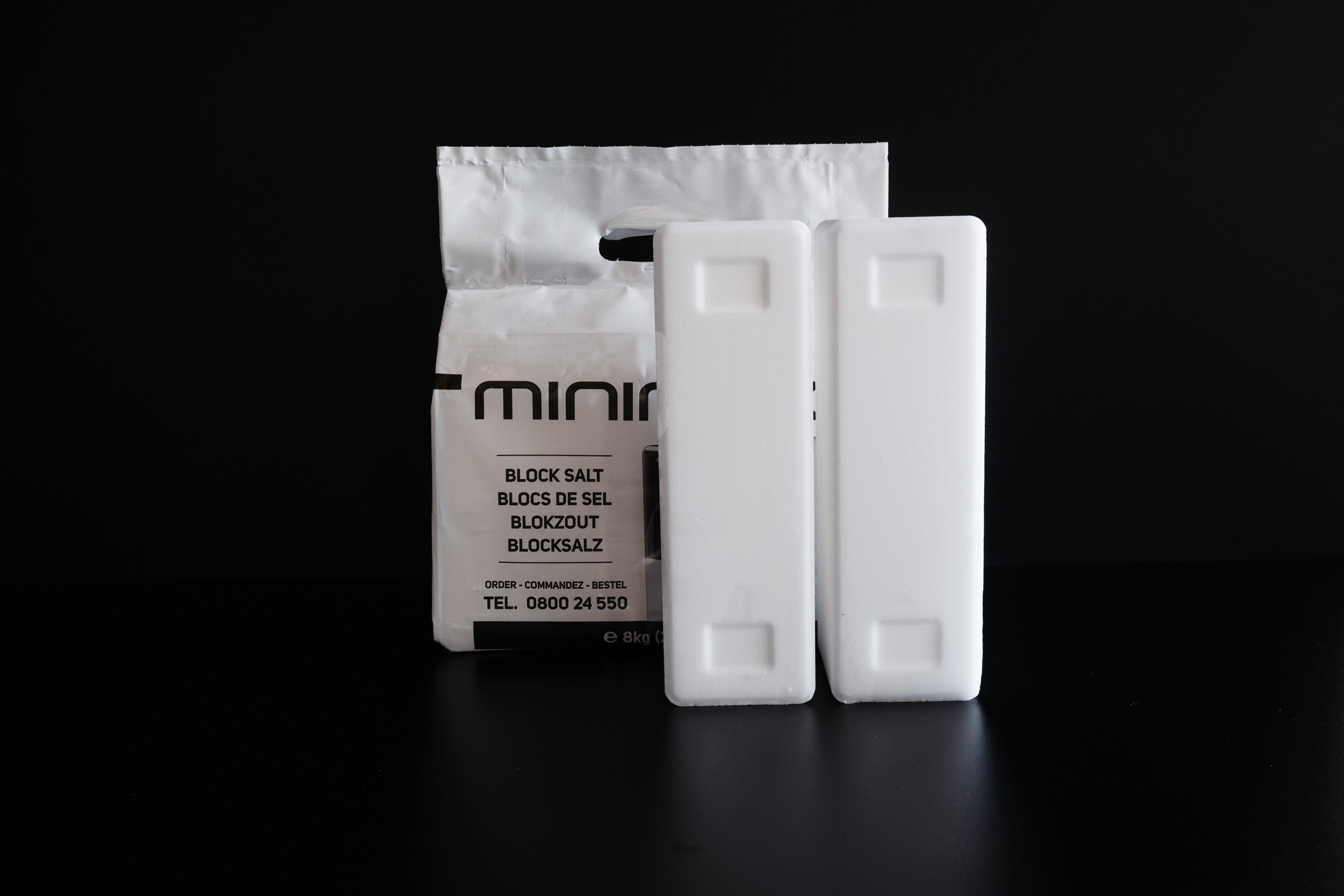 Deux blocs de sel Minimax pour adoucisseur d’eau sur fond noir.